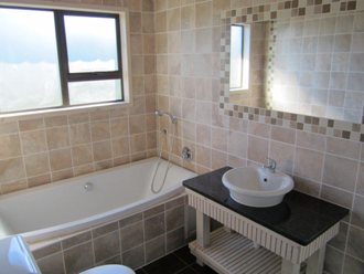 Tiled Bathroom With Detail Around A Mirror